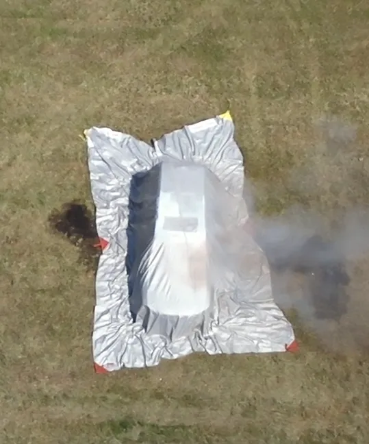 Aerial view: car covered with the WINGS fire blanket during a firefighting demonstration